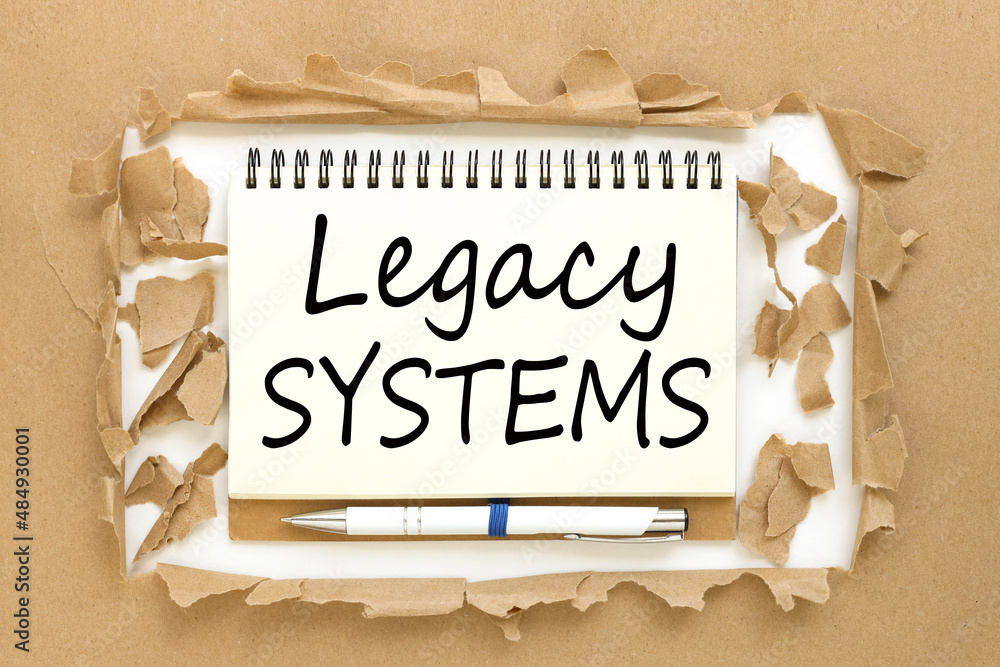 Aufkleber legacy systems. business concept open notepad with text on torn paper background