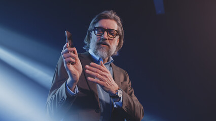 Creator in a suit demonstrating a new modern smartphone design and talking about its advantages on...