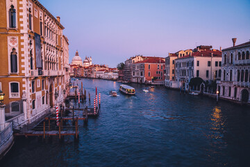 Fototapeta na wymiar Romantic city in Europe with motorboats floating on Grand Canal during evening time for exploring Venice, Italian architecture and picturesque historic center with ancient landscape for discovering