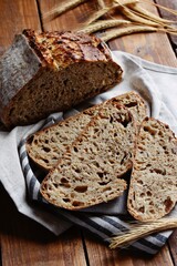 Homemade sourdough bread with seeds on the wooden background