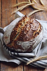 Homemade sourdough bread with seeds on the wooden background