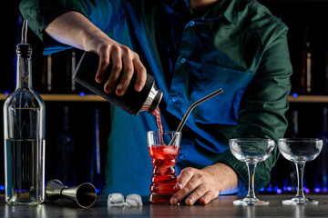 Bartender's hands serving cocktails on bar counter in a restaurant, pub. Mixed drinks. Alcoholic cooler beverage at nightclub on dark background