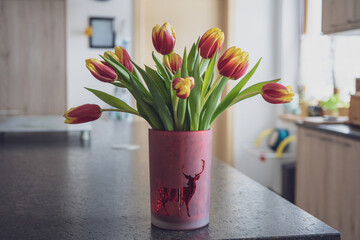 flower vase with colorful tulips on the table in the kitchen