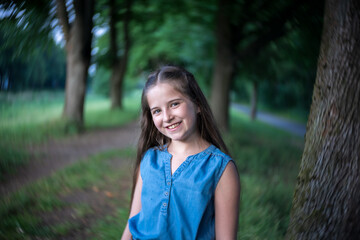 Fototapeta premium Portrait of a beautiful girl with long hair in nature.