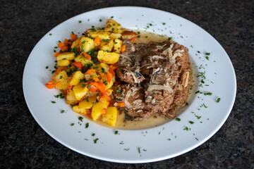 ready to eat - fried potatoes and fried herring on a white plate