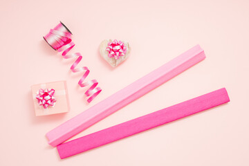 Gift box, ribbons and heart on pastel pink background. Valentine's Day or Love concept.  Flat lay.