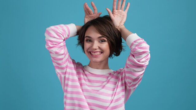 Lady make hands shot grimace tongue out ears isolated blue color background