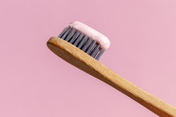 Ecological toothbrush made from natural bamboo. Sustainable lifestyle concept, zero waste. Copy space. Pink background