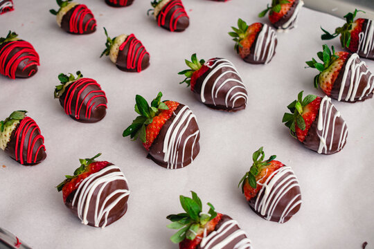 Making Chocolate Covered Strawberries and Pineberries: Freshly made candied berries on a parchment paper lined sheet pan