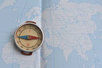 compass on the background of a contour map. journey. geography. west east concept