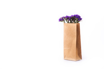 Blue, dried flowers in brown paper bag on the white background.. Close up. Top view, copy space. isolate