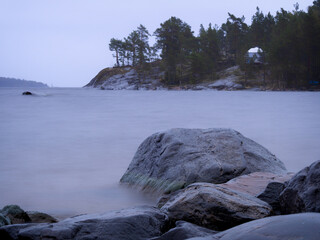 Lake Ladoga on a cloudy day. Stones and water are like fog. Long exposure