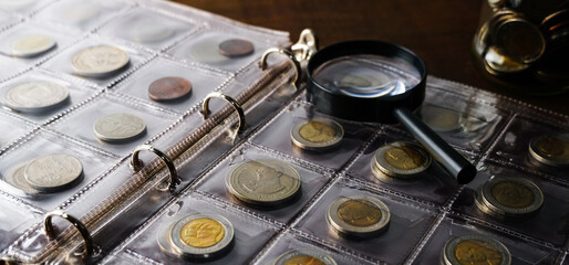 Old collectible coins on a wooden table. Dark background. Banner. Numismatics, Coins in the album....