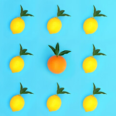 Odd one out concept with lemon and orange fruit with leaf sprigs in a  isometric pattern on blue background. Minimal contrast abstract design. High in antioxidants, bioflavonoids and vitamin c.