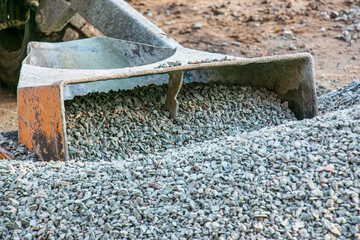 Mobile concrete mixer at the construction site. Close-up of gravel being loaded into a concrete...