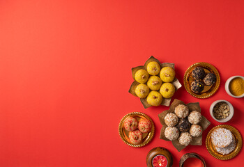 traditional indian sweets on red background flat lay
