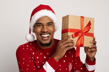 Funny black guy Santa Claus holding Christmas present by ear