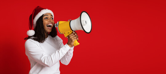 Excited black lady in Santa hat using megaphone