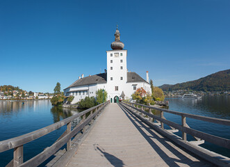 Fototapeta na wymiar bridge to Orth lake castle on a island, lake Traunsee tourist attraction, austria