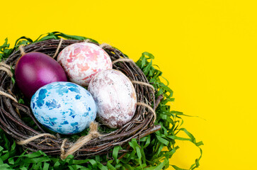 Top view of color easter haqndmade eggs and nest flatlay. Trendy minimal design spring background. Space for text. Stuio Photo