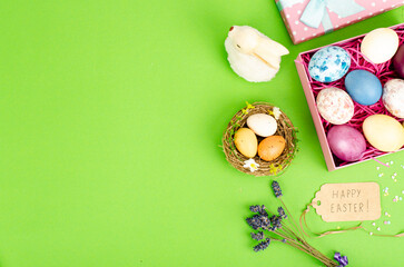 Multicolored eggs in open gift box. Concept of the Happy Easter holiday, greeting card template. Studio Photo