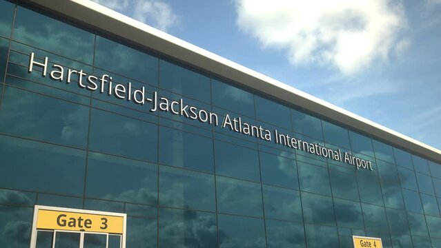 Commercial plane landing reflecting in the windows with Hartsfield-Jackson Atlanta International Airport text