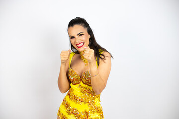 Young beautiful woman wearing carnival costume over isolated white background Punching fist to...