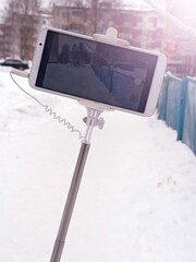 Smartphone on a selfie stick in winter