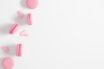Valentine's Day background. Pink macaroons and pink hearts on white background. Flat lay, top view, copy space