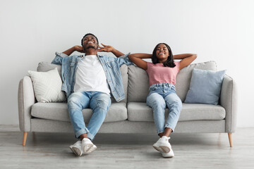 Black couple having rest at home on the couch
