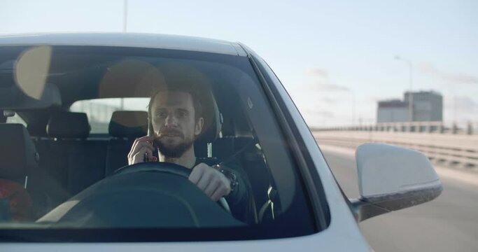 Man driving and talking on the phone in Los Angeles on a sunny day