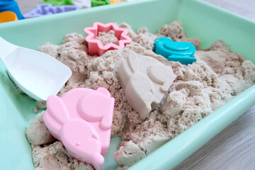Light kinetic sand and multi-colored figures, sand for modeling and construction. Educational game...