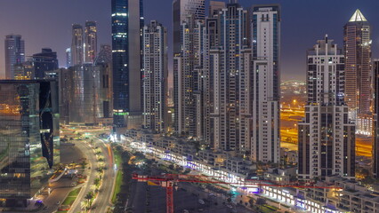 Obraz na płótnie Canvas Bay Avenue with modern towers residential development in Business Bay aerial night to day timelapse, Dubai