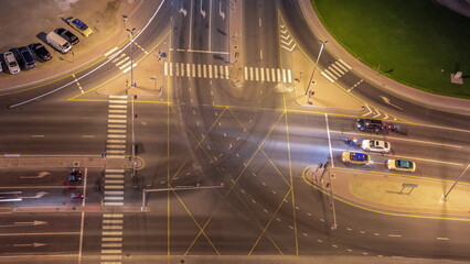 Aerial looking down view of city traffic on a crossroad in Dubai Business bay night timelapse.