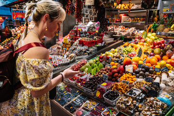 Asian woman choosing fruits in market - obrazy, fototapety, plakaty