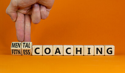 Mental or fitness coaching symbol. Coach turns cubes and changes words Fitness coaching to Mental coaching. Beautiful orange background, copy space. Mental or fitness coaching concept. - obrazy, fototapety, plakaty