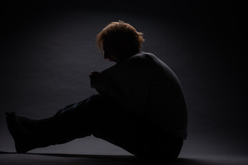 Silhouette of boy sitting and screaming