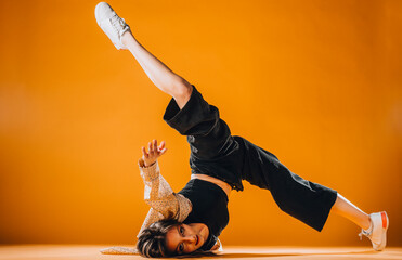 Gorgeous dance performer dancing on orange background