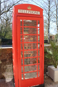 K6 telephone box designed by Giles Gilbert Scott grade 2 listed in Upholland with full size wooden painted soldier in red black and gold uniform inside
