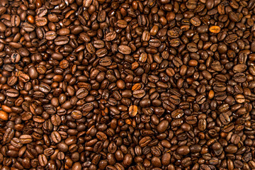 Coffee beans background. Top view of roasted coffee beans spread out on the surface.