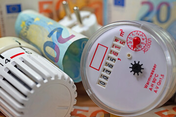 Wasserzähler, Thermostat und Geldscheine symbolisch für Mietnebenkosten