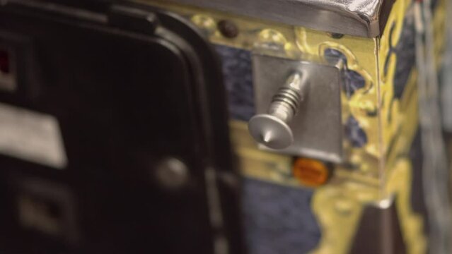 Hand lunches ball on spring on pinball table a vintage game machine