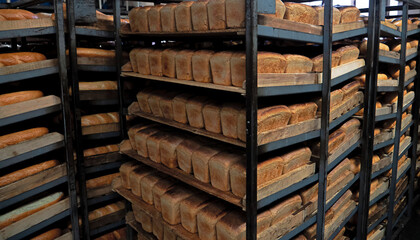 Shelves with fresh bread. Finished bread products to be shipped to stores. Loaves of bread on industrial shelves