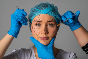 Horizontal shot of woman under going a face lift surgery. Female face with dotted line drawn and...