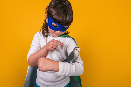 Child in superhero costume with parrot