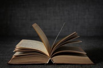 Old open book on a dark background close-up