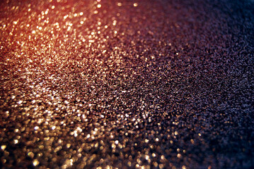 Golden de focused sparkle glitter background with golden particles close up