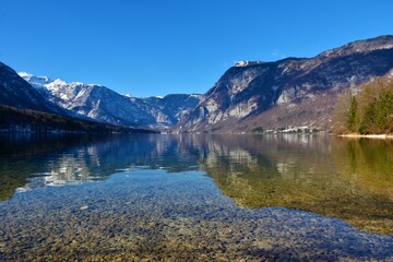 View of Bohinj lake in winter with a reflection of the mountains in the water in Julian alps, Slovenia