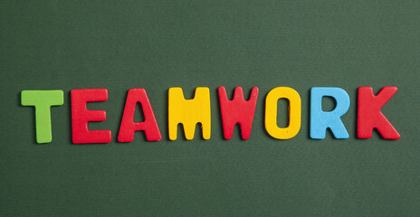 Colorful word Teamwork on green background.