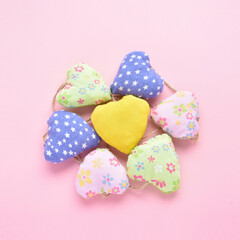 hand-sewn multi-colored hearts on a pink background